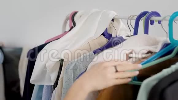 女人正在研究挂在衣架上的衣服选择衣柜对现代女性来说非常重要视频的预览图