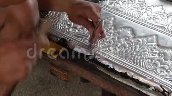 在银色面板上工作的工匠的双手视频的预览图