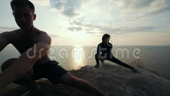 日出时男女青年练习晨练体操视频的预览图