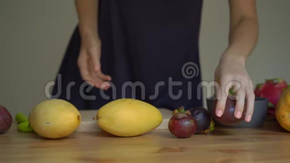 一位年轻女子慢镜头把热带水果放在桌子上视频的预览图