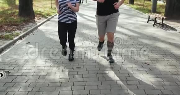 体育夫妇在公园里一起跑步年轻人在户外健身训练时一起慢跑男子和妇女体育视频的预览图