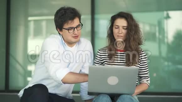 两个在夏日外面用笔记本电脑工作的商人视频的预览图