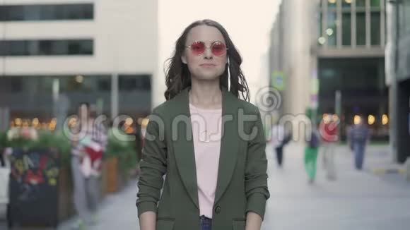 一个漂亮的年轻女人在秋天的街道上表现得很好视频的预览图