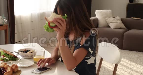 可爱的饥饿的女人吃着美味的三明治享受食物视频的预览图
