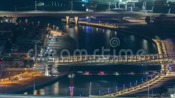迪拜水上运河带有人行天桥从市中心的摩天大楼屋顶上经过夜间时间视频的预览图