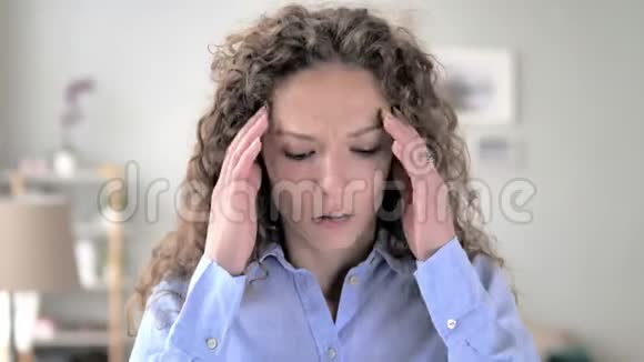 头痛办公室里紧张的卷发女人的肖像视频的预览图