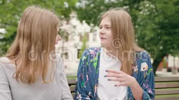 年轻女士在城里的长椅上讲话视频的预览图