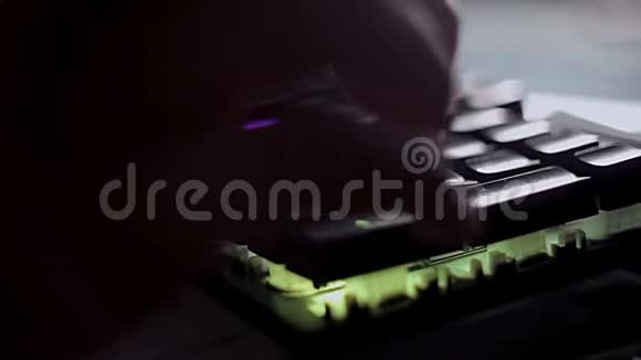 在黑暗的房间里程序员在背光键盘上输入代码在电脑上热情地工作视频的预览图