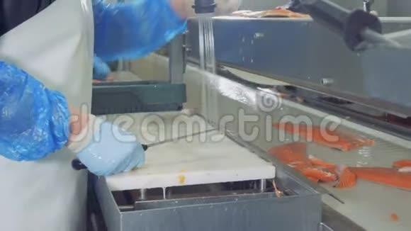 一个工人把鱼片上的鱼鳍割下来关上视频的预览图