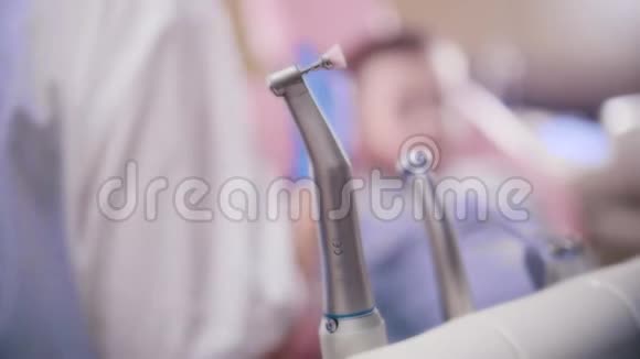 牙医医学牙医从看台上拿起抛光仪慢动作视频的预览图