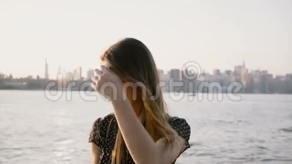 快乐微笑的白人女孩在镜头前摆姿势的肖像在纽约日落海滩天际线4K戴上太阳镜视频的预览图
