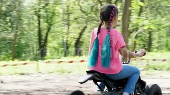 夏日在公共松城公园小女孩穿着一件鲜艳的粉红色T恤扎着彩色辫子骑着一辆视频的预览图