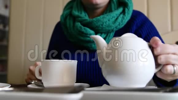 一个女人从茶壶里往杯子里倒茶视频的预览图