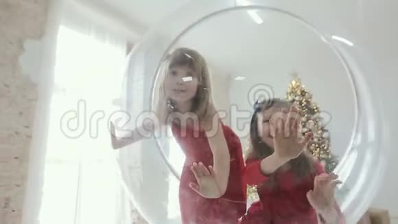 两个女孩在圣诞节室内玩圆椅视频的预览图