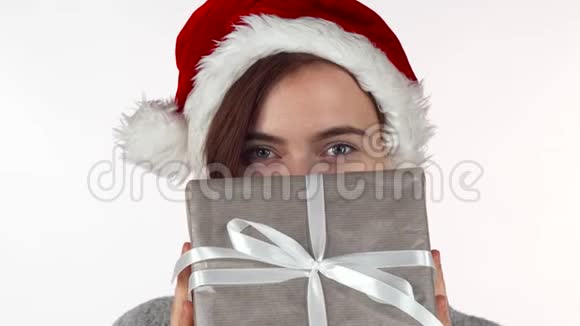漂亮的圣诞女人把脸藏在礼物盒后面视频的预览图