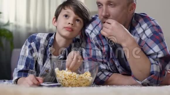 父亲在看电影的时候抱着小儿子带着爆米花回家视频的预览图