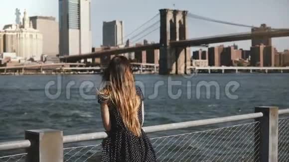 富有戏剧性的一幕充满快乐笑容的白种人女人头发飞扬欣赏着著名的纽约市河畔天际线视频的预览图