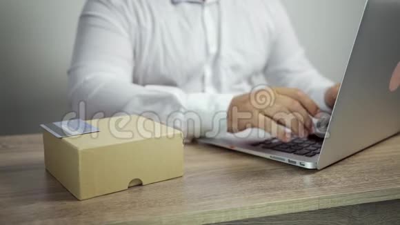 网上购物概念男人手拿信用卡用笔记本电脑信用卡和货物在桌子上视频的预览图