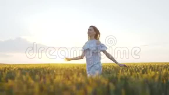 穿裙子的快乐女孩跑在一个4K的小绿野里视频的预览图