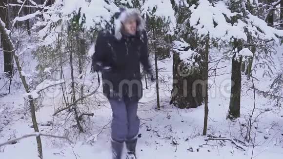 不久的圣诞节快乐的人在冬天的森林里跳舞摇动树木视频的预览图