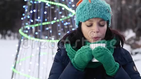 一个女孩在圣诞树旁吹着烟喝茶视频的预览图