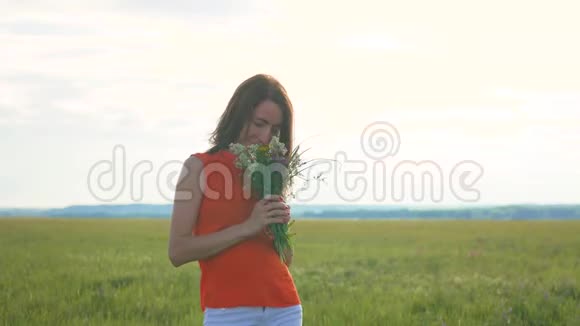 美丽的女孩田野的花站在草地上视频的预览图