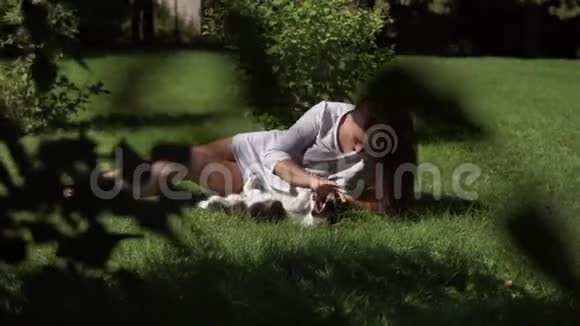 小女孩留着长发带着一只小狗在公园的草地上心情很好4K视频的预览图