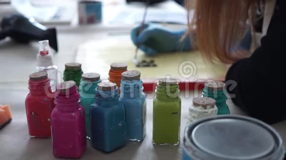 五彩瓶的颜料女孩艺术家在彩色板上画字母视频的预览图