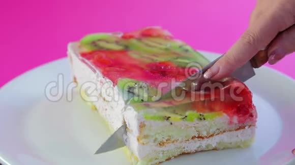 女人手拿刀把水果蛋糕切成块视频的预览图