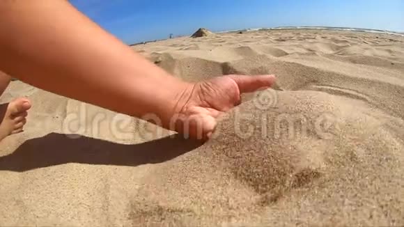 慢动作女孩拿起一把沙子在她的手掌和洒视频的预览图