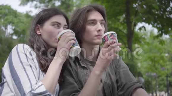 年轻快乐的一对穿着便服的夫妇在公园里聚在一起约会学生们在喝咖啡视频的预览图