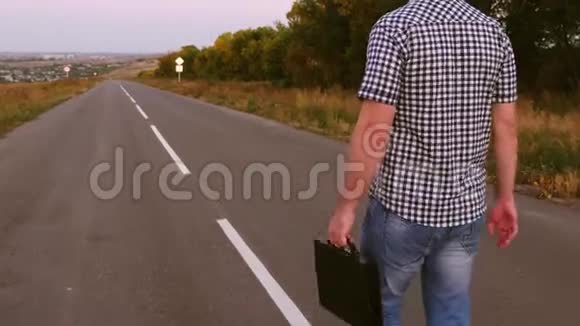 年轻的男企业家走在路上手里拿着一个黑色公文包手里拿着文件视频的预览图