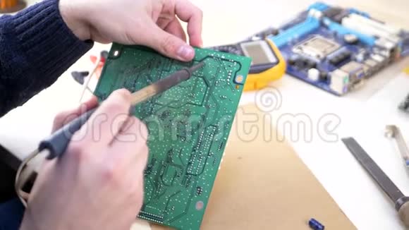 年轻电脑技师焊接绿色主板视频的预览图