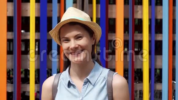 微笑的女人站在彩色的墙壁背景上户外度假的免费游客视频的预览图