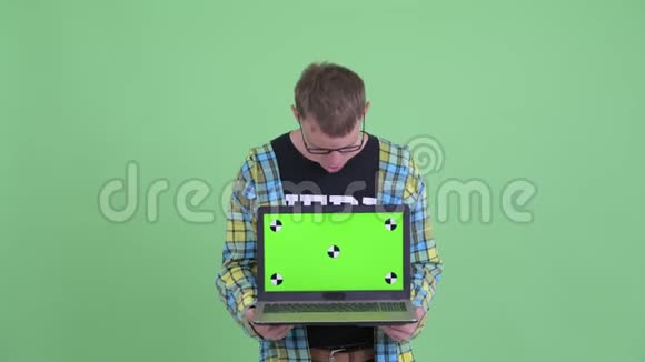 快乐的书呆子男人展示笔记本电脑的肖像看上去很惊讶视频的预览图