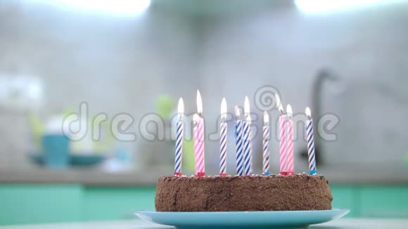 厨房里有蜡烛火焰的生日蛋糕生日甜点和蜡烛视频的预览图