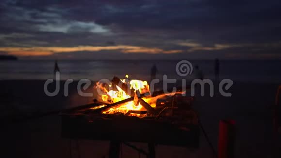 日落时分在美丽的海滩上在烤架上缓缓点燃篝火视频的预览图