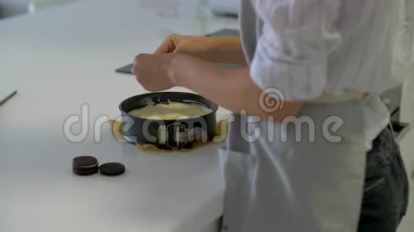 为蛋糕做奶油的过程女人手把饼干叠成馅饼视频的预览图