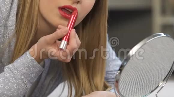 年轻女士用红色口红化妆尝试颜色时尚视频的预览图