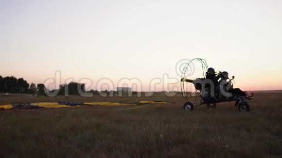 机动滑翔伞与一个女孩和一个男人在机场起飞加速和起飞的天空降落伞视频的预览图