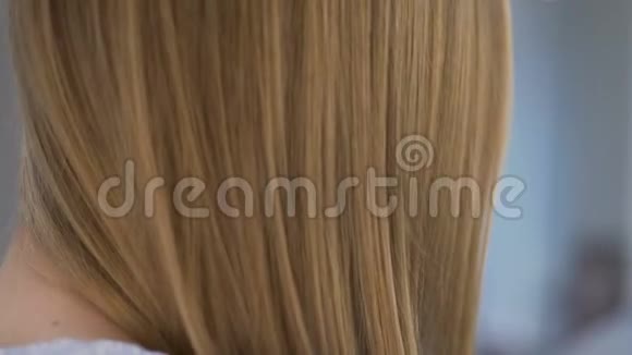 年轻女子梳着一头金发上面涂着无染料氨自然美丽视频的预览图
