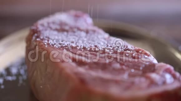 用百里香和大蒜放在木板上的鲜熟牛排视频的预览图