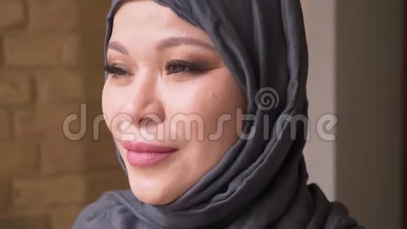 穆斯林成年成功女员工戴着头巾看着镜头在室内开心地微笑的特写镜头视频的预览图