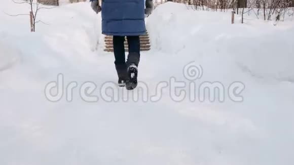 特写女人她的腿在雪梯上上升楼梯白天下雪时在城市的冬季公园视频的预览图