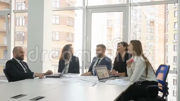 办公室工作人员一家大公司的员工两个年轻的男人和三个年轻的女人讨论公司的问题结束视频的预览图