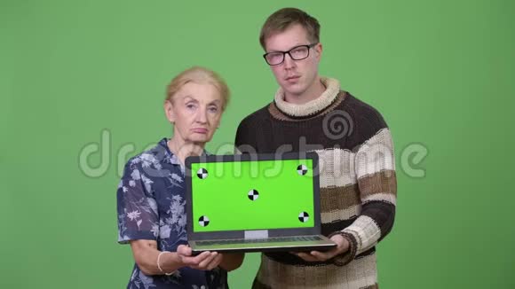 快乐的祖母和孙子一起展示笔记本电脑视频的预览图