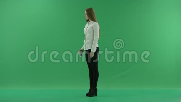 年轻的女商人正站在绿色的屏幕上自拍视频的预览图