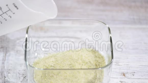 浇热水做绿色果冻在玻璃碗里搅拌果冻视频的预览图