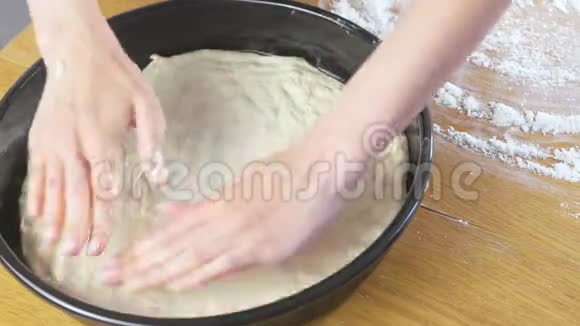 女人手把酵母面团放在圆形烤片上做披萨视频的预览图
