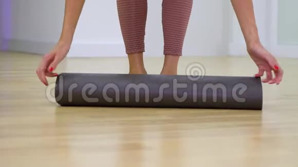 年轻女子双脚展开垫子踩在垫子上准备训练视频的预览图